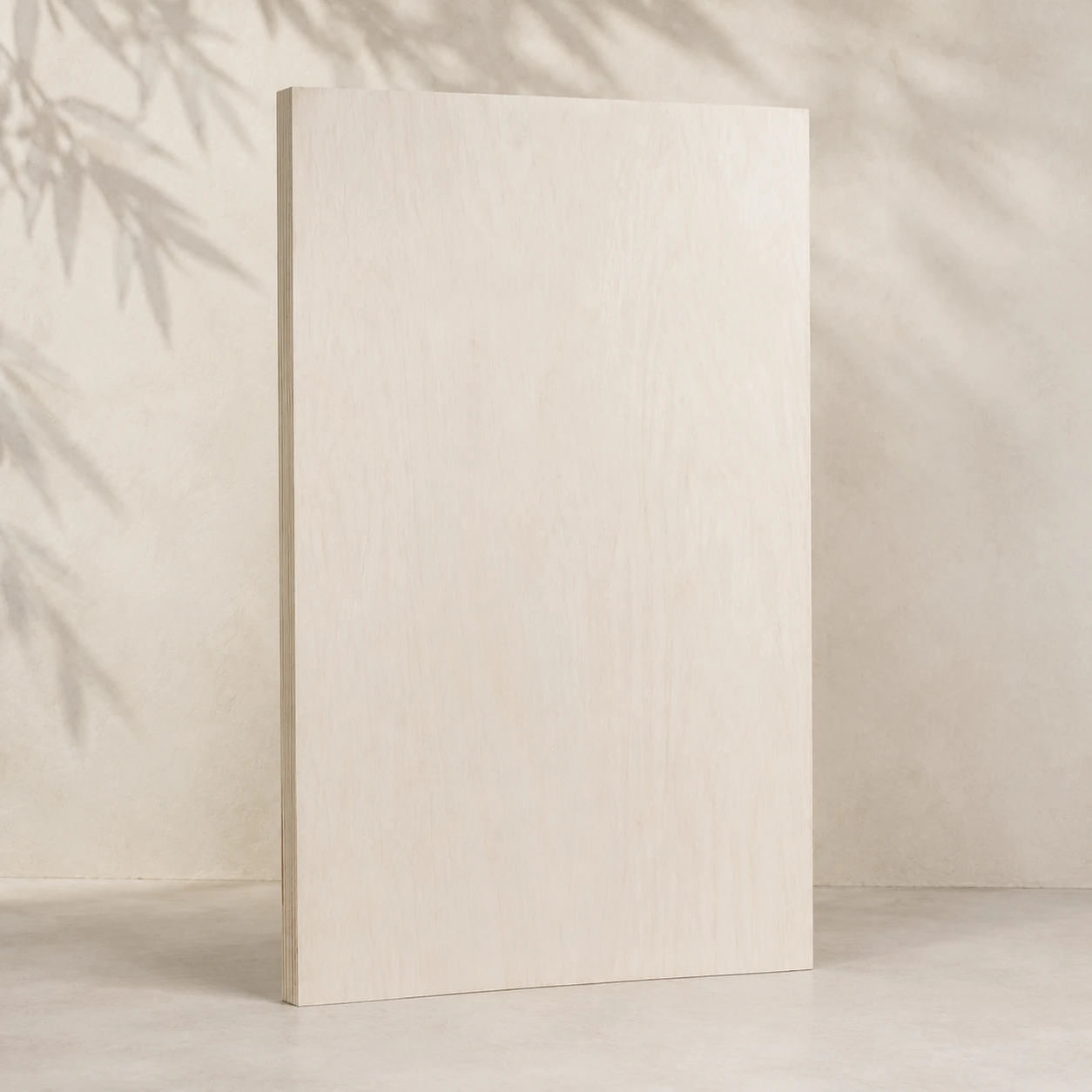 Whole sheet of bleached poplar-faced plywood, very pale cream face, leaning against a plaster wall